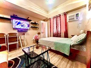 een woonkamer met een bed en een televisie bij Across Sm City Cebu Sunvida Tower Studio Unit in Cebu City