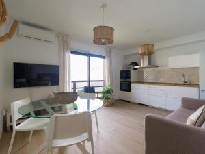 cocina y sala de estar con mesa de cristal y sillas en Arena y Calma Jandia con aire acondicionado, en Morro del Jable