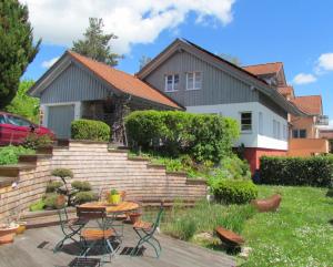 a house with a garden with a table and chairs at Haus Bergblick in Kißlegg