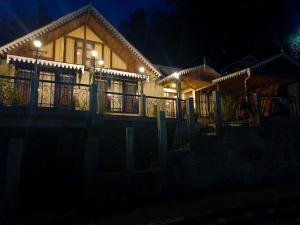 a house with lights on the balcony at night at Marigold Manor Homestay in Darjeeling