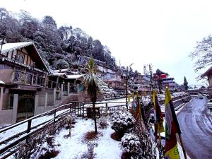 a snow covered town with buildings and a street at Marigold Manor Homestay in Darjeeling
