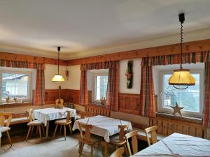 un restaurante con 2 mesas, sillas y ventanas en Apartments HAUS SCHÖN - Preise inclusive Pitztal Sommer Card, en Jerzens