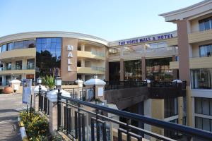 un edificio con un cartel que lee más leche y hotel en The Voice Hotel, en Entebbe