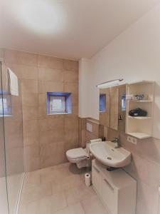 a white bathroom with a sink and a toilet at Apartments HAUS SCHÖN - Preise inclusive Pitztal Sommer Card in Jerzens