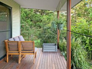 a porch with two wooden chairs at Quiet Private Nimbin Townhouse in Nimbin