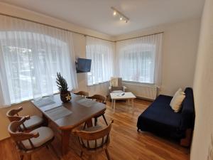 sala de estar con mesa, sillas y sofá en Apartments HAUS SCHÖN - Preise inclusive Pitztal Sommer Card, en Jerzens