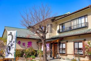 富士吉田的住宿－赤富士亭，前面有棵树的建筑