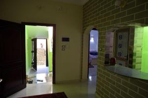 a hallway with green walls and a brick wall at Nubian Queen Guest House in Aswan