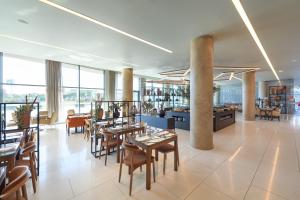 un restaurante con mesas y sillas y un bar en Meliá Lisboa Aeroporto, en Lisboa
