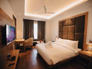 a hotel room with a large bed and a desk at Clarks Inn Express, Dehradun in Dehradun