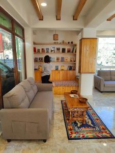 a woman in a living room with a couch and a table at Soke Boutique Homestay in Gangtok