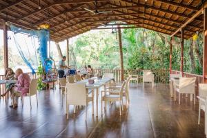 a restaurant with tables and chairs and people sitting at them at KAYANIV Ayurveda & Wellness Resort in Mandrem