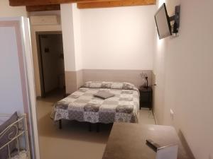 a small bedroom with a bed and a table at A New Guesthouse in Pavia