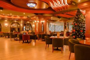 a restaurant with a christmas tree and tables and chairs at HOTEL IMPERIAL STRUGA in Struga