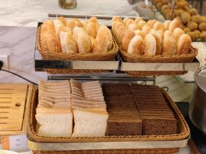uma exibição de pães e outros alimentos em cestos em Muong Thanh Luxury Nhat Le Hotel em Dong Hoi