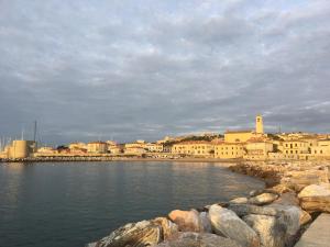 a view of a city from the water with rocks at Giardino Sud - a pochi passi dal mare in San Vincenzo