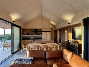 a living room with a brown couch and a table at Native Dog Cabin in Bremer Bay
