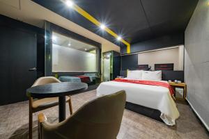 ein Hotelzimmer mit einem Bett und einem Tisch in der Unterkunft Boutique Hotel XYM in Suwon