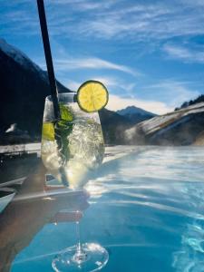 a drink with a lemon slice on top of a pool at Hotel Zalwonder in Ischgl