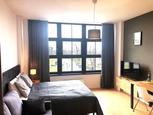 um quarto com uma cama e uma grande janela em Apartimento Hydral Magari em Breslávia