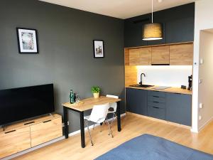 a kitchen with a desk and a table with a tv at Apartimento Hydral Magari in Wrocław