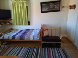 - une chambre avec un lit, une fenêtre et une chaise dans l'établissement TRADITIONAL HOUSE, à Monemvasia
