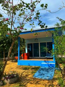 a small house with a blue roof at Twocans Resort KohMak - SHA in Ko Mak
