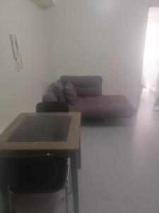 Cette chambre comprend un bureau, une table et un canapé. dans l'établissement Sobere Unit, à Manille