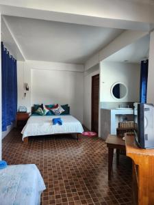 Un dormitorio con una cama y un televisor. en Petit Suncliff Resort, en Haad Rin 116 fotos más