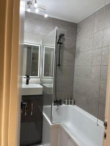 y baño con ducha, bañera y lavamanos. en Self-catering fully equipped apartment in Vauxhall en Londres