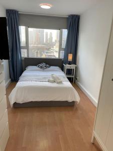 a bedroom with a bed with a large window at Self-catering fully equipped apartment in Vauxhall in London
