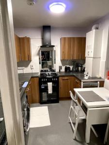 a kitchen with a stove and a table in it at Self-catering fully equipped apartment in Vauxhall in London