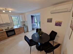 a kitchen and living room with a table and chairs at Lavanda apartman 1 in Cres
