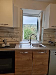 a kitchen with a sink and a window at Lavanda apartman 1 in Cres
