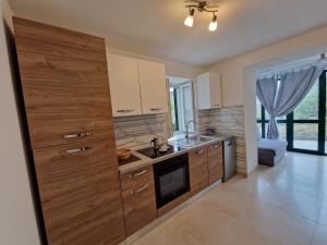 a kitchen with wooden cabinets and a sink at Lavanda apartman 1 in Cres