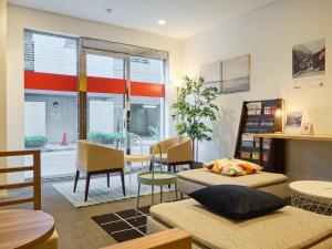 um quarto com duas camas e uma mesa e cadeiras em Tabist Ginza em Tóquio