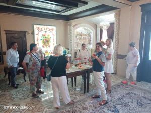 a group of people standing around a table in a room at EDEM Plaza in Bukhara
