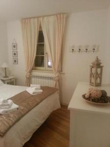 トリエステにあるIl Borgoのベッドルーム1室(ベッド1台、テーブル、窓付)