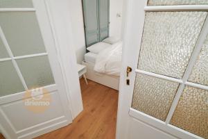 Una puerta que conduce a un dormitorio con cama en Appartement La Cabane, en De Panne
