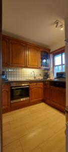 une cuisine avec des placards en bois et un appareil en acier inoxydable dans l'établissement Apartment Jenny, à Garmisch-Partenkirchen