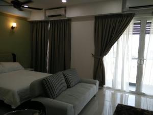 a bedroom with a bed and a couch and a window at DELUXE HOMESTAY @ D PERDANA in Kota Bharu