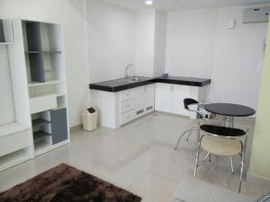a white kitchen with a table and chairs in it at DELUXE HOMESTAY @ D PERDANA in Kota Bharu