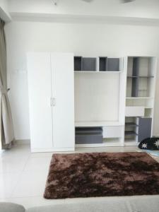 a living room with white cabinets and a brown rug at DELUXE HOMESTAY @ D PERDANA in Kota Bharu