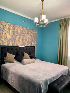 een slaapkamer met een groot bed met blauwe muren bij Vernatoon Guest House in Vagharshapat