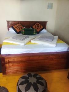 a wooden bed with white sheets and pillows on it at Dream view in Ella