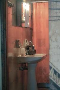 a bathroom with a sink and a red shower curtain at Georgia's Village House in Kondóstavlos