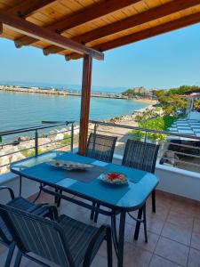 una mesa y sillas en un balcón con vistas al agua en Aegean Balcony, en Skala Kallirakhis