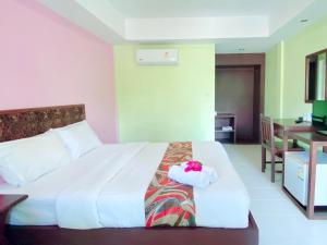 a hotel room with a bed with a towel on it at Baan Karnjana Hotel Samui in Lamai