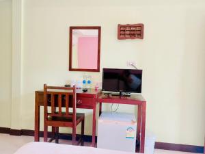 a desk with a computer and a chair in a room at Baan Karnjana Hotel Samui in Lamai