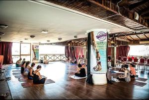 um grupo de pessoas sentadas numa sala a fazer yoga em Adrasan Klados Hotel em Adrasan